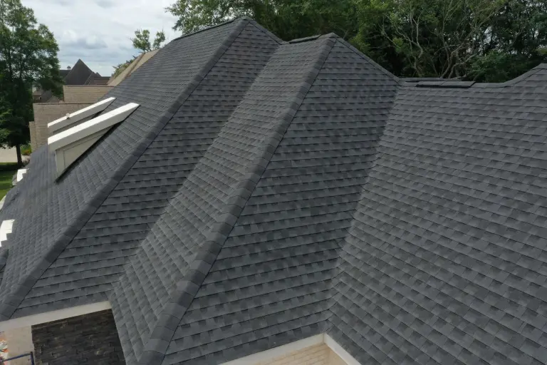 A large dark gray shingle roof with multiple hips and valleys