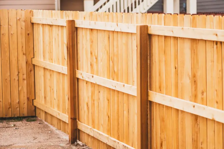 A newly built cedar privacy fence with vertical pickets and horizontal rails