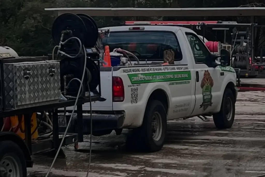 A Jade Exterior Services pickup and hose reel trailer parked on a freshly washed lot